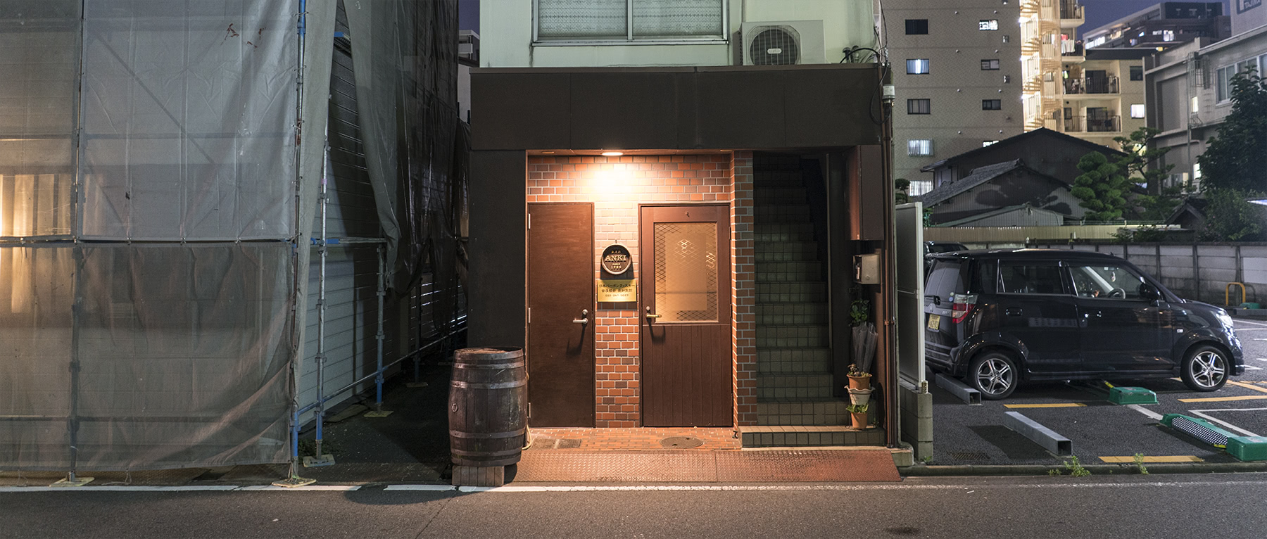 A quiet street and an empty bourbon barrel mark the entrance to the bar